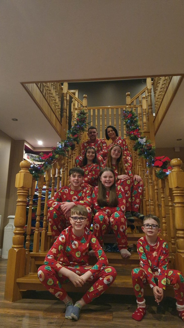 Die Familie sitzt mit Weihnachts-Schlafanzügen auf der Treppe  | © Venke 